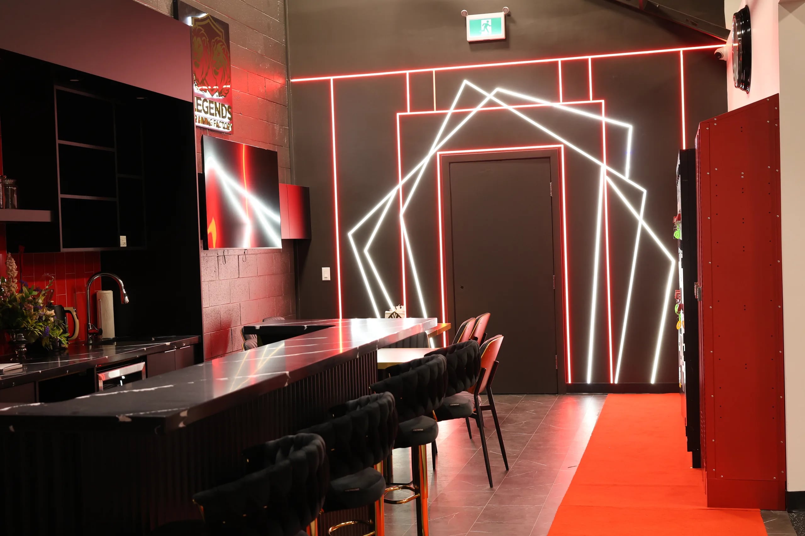 The Legends Training Factory lounge with red neon lighting.